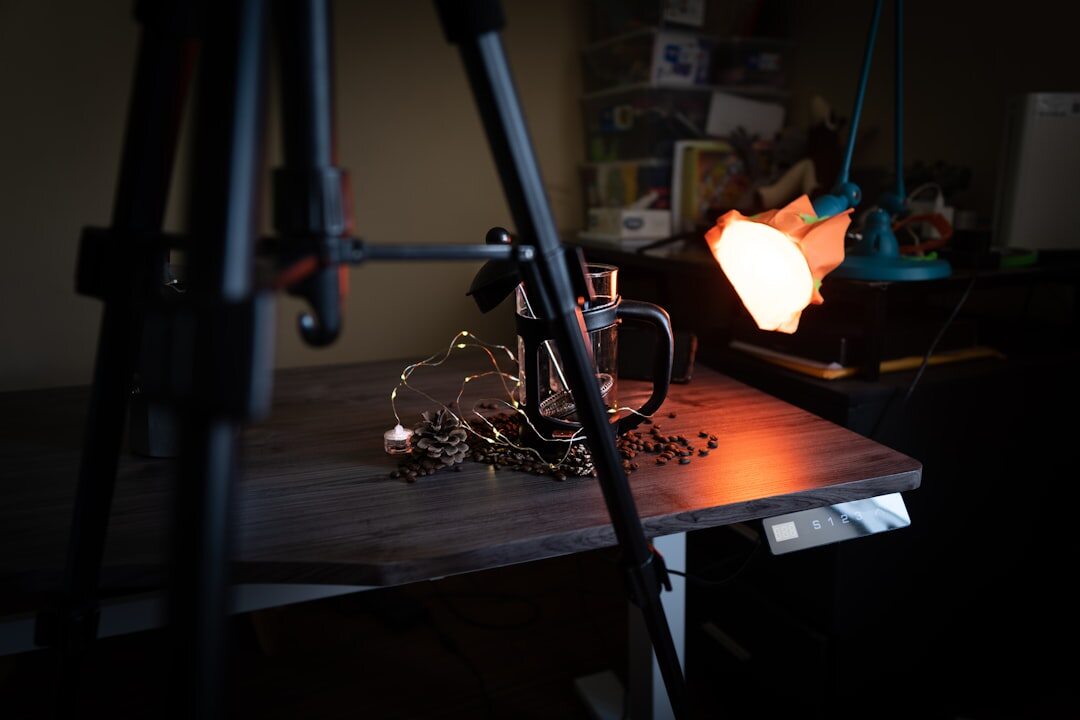 Small video studio with camera on tripod facing a desk with laptop and ring light