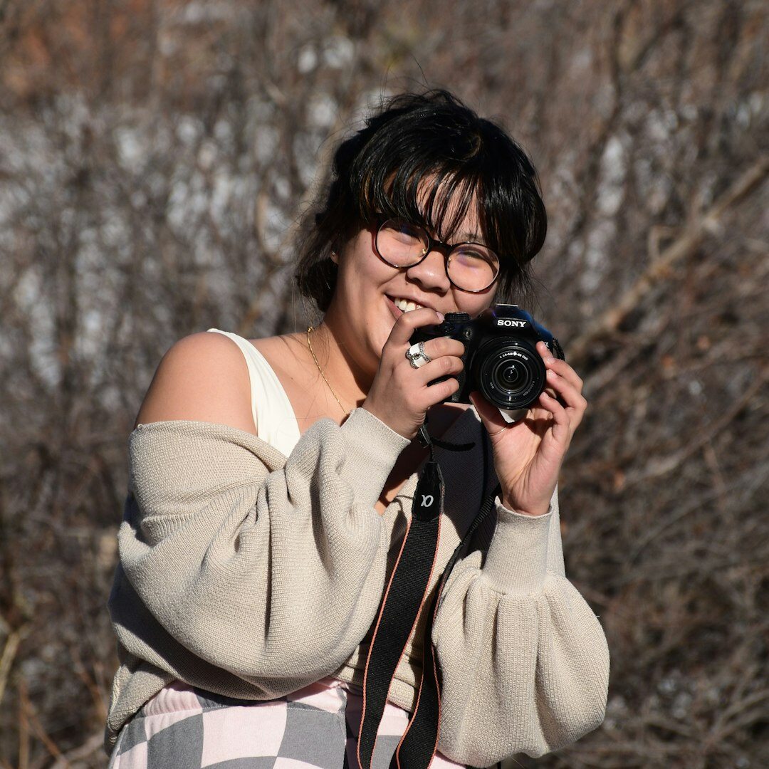 Young Turkish woman looking through a camera viewfinder in a studio